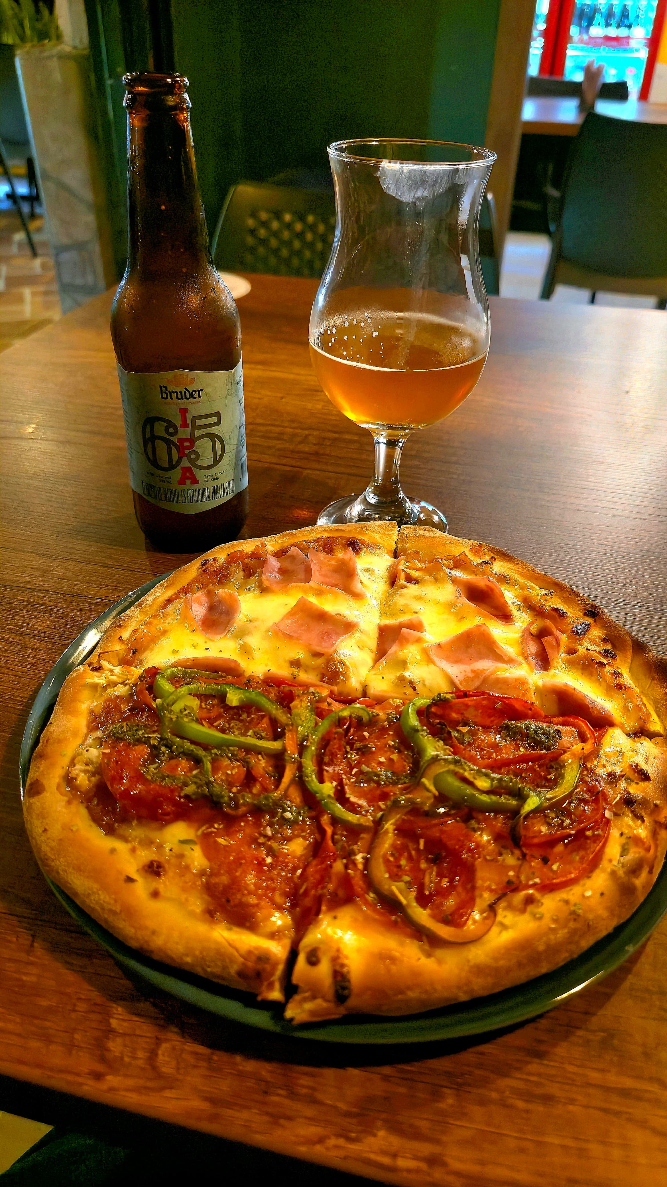 Pizza artesanal acompañada de cerveza en una mesa de Monster Pizza